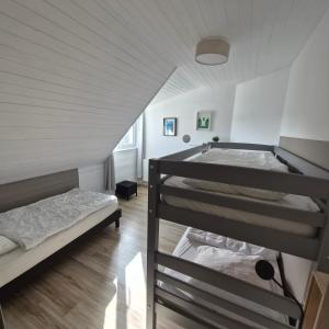 a attic bedroom with two bunk beds and a staircase at "La Villa du Cap" avec piscine intérieur, billard et à 5 minutes de la plage et des commerces! in Fouesnant +42 photos