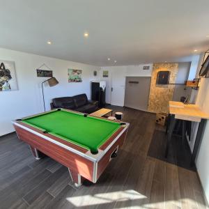 a living room with a pool table and a couch at "La Villa du Cap" avec piscine intérieur, billard et à 5 minutes de la plage et des commerces! in Fouesnant