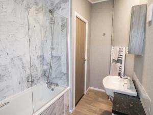 a bathroom with a shower and a tub and a sink at Lily's Lodge in Morecambe +23 photos