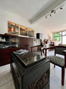a living room with a table and a kitchen at Casa ELA Candelaria in Antigua Guatemala