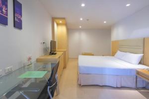 a hotel room with a bed and a desk at The Tivoli Hotel in Bangkok +8 photos