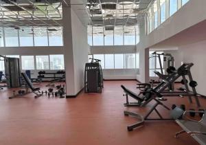 a gym with treadmills and exercise equipment in a building at Panoramic Sea apartment & Skyline View Private Room in Sharjah