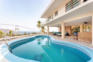 a swimming pool in front of a house at Private villa, 6 bedrooms, 2 pools with views in Acapulco