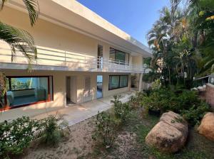 a large house with a balcony and palm trees at Private villa, 6 bedrooms, 2 pools with views in Acapulco