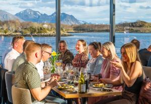 a group of people sitting at a table in a restaurant at Ringstad Resort in Bø