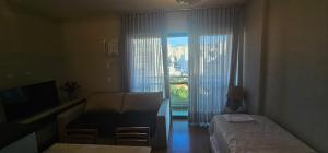 a bedroom with a bed and a window with a view at Charme e Conforto na Savassi in Belo Horizonte
