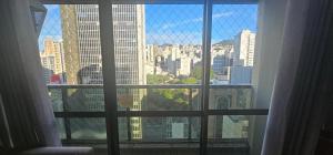 a view of a city skyline from a window at Charme e Conforto na Savassi in Belo Horizonte