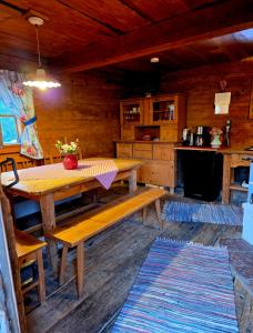 a dining room with a wooden table and a kitchen at Augihütte in Abtenau