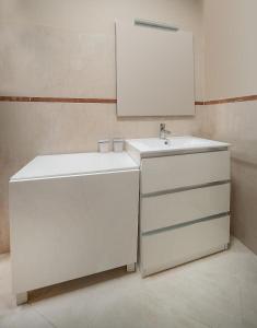 a white bathroom with a sink and a mirror at Nest on The Lake in Marone +43 photos