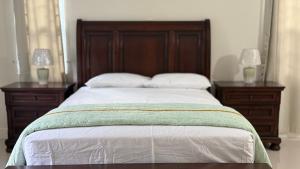 a bedroom with a bed with two dressers and two lamps at Wrightian in Kupuis