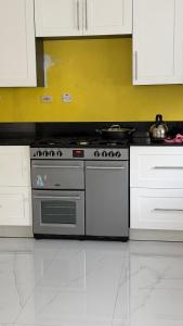 a kitchen with a stove and white cabinets at Wrightian in Kupuis