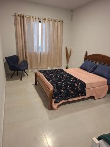 a bedroom with a bed and a chair and a window at Apartamento Brisa do Mar - Casas confortáveis para casal e acompanhantes com garagem in Búzios