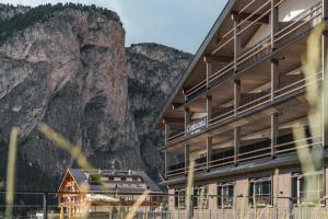 a building with a mountain in the background at Hotel Continental Dolomites in Selva di Val Gardena