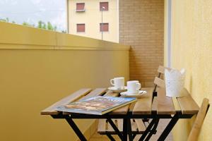 a wooden table with cups and saucers on a balcony at I Castelli - Alle 5 Torri in Mezzolombardo