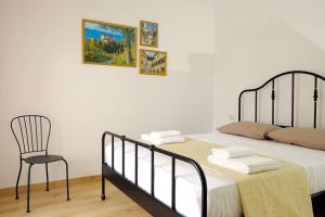 a bedroom with a bed and a chair at I Castelli - Alle 5 Torri in Mezzolombardo