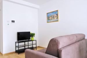 a living room with a couch and a tv at I Castelli - Alle 5 Torri in Mezzolombardo