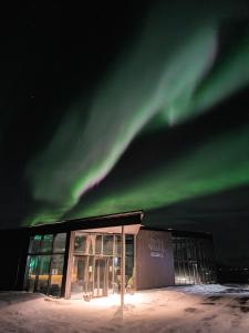 an office building with the northern lights in the sky at Ringstad Resort in Bø +9 photos