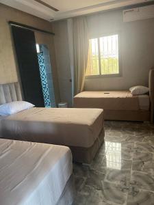 a bedroom with two beds and a window at villa lina in Aït Mazou