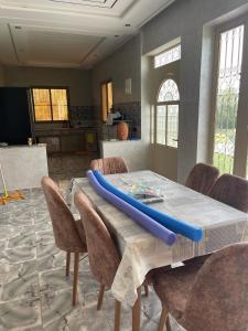 a table with a blue surfboard on top of it at villa lina in Aït Mazou