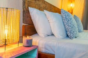 a bed with pillows and a candle on a table at Vito Hotel Boutique Taganga in Taganga +35 photos
