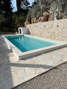 a swimming pool in front of a stone wall at House Damić in Korčula