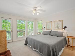 a bedroom with a bed with a ceiling fan and windows at Smith Lake Retreat - Close To Trident Marina in Crane Hill
