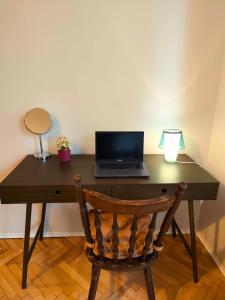 a wooden desk with a laptop computer on top of it at Serenity and cosy Lodge, next to NDK! in Sofia +3 photos