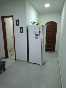 a kitchen with a white refrigerator in a room at Apartamento Brisa do Mar - Casas confortáveis para casal e acompanhantes com garagem in Búzios