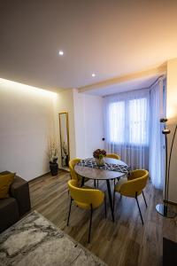 a living room with a table and yellow chairs at Residenza La Chiave in Mantova