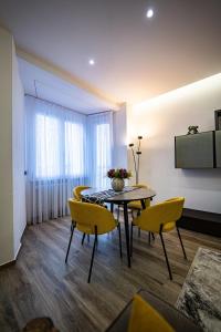 a dining room with a table and yellow chairs at Residenza La Chiave in Mantova