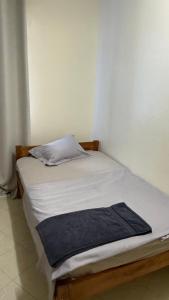 a small white bed with a blue blanket on it at Noorhaven stay in Watamu +4 photos