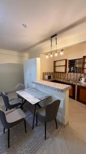 a dining room with a table and chairs and a kitchen at Noorhaven stay in Watamu