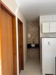 eine kleine Küche mit Spüle und Kühlschrank in der Unterkunft Flat in Japaratinga