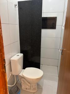 ein Badezimmer mit Toilette und Dusche in der Unterkunft Flat in Japaratinga