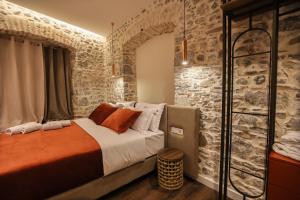a bedroom with a bed and a stone wall at NOMA Boutique Hotel in Shkodër