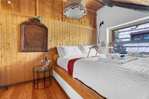 a bedroom with a bed in a wooden wall at La Grangia - mountain loft in Rollieres