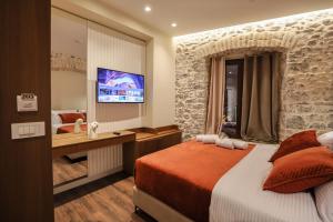 a hotel room with a bed and a television at NOMA Boutique Hotel in Shkodër