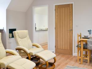 a living room with two chairs and a table at Leveret Lodge in Burgh