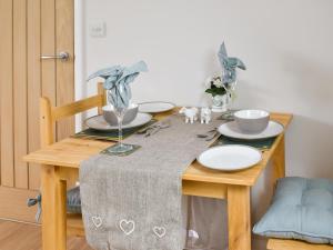 a wooden table with a table cloth on top of it at Leveret Lodge in Burgh