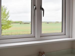 a window with a view of a green field at Leveret Lodge in Burgh +13 photos