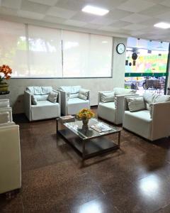 a living room with couches and a coffee table at Bandeirantes Hotel in Cuiabá