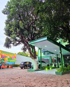 a bus stop with a tree in a parking lot at Bandeirantes Hotel in Cuiabá
