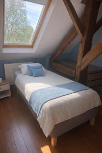 a large bed in a room with a window at Le refuge de Séve - Loft de Yves in Momignies