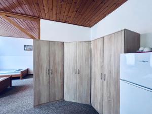 a kitchen with wooden cabinets and a refrigerator at Ubytování Přimda in Přimda