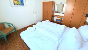 a hotel room with a bed and a chair at Boddenhof Apartment 48 - Terrasse für Hundefreunde in Buschvitz