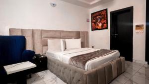 a bedroom with a large bed and a blue chair at Luxury Hotel Deluxe Room - Sleeps 2 - Gym - Pool in Lekki