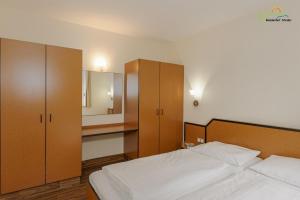 a bedroom with two beds and cabinets and a mirror at Boddenhof Apartment 44 - Terrasse, Hund willkommen in Buschvitz