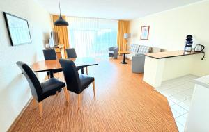 a living room with a dining room table and chairs at Boddenhof Apartment 46 - ebenerdig, tierfreundlich in Buschvitz