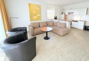 a living room with a couch and a table at Boddenhof Apartment 50 - modern und freundlich, viel Sonne in Buschvitz