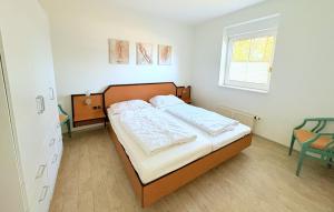 a bedroom with a bed and a window at Boddenhof Apartment 50 - modern und freundlich, viel Sonne in Buschvitz